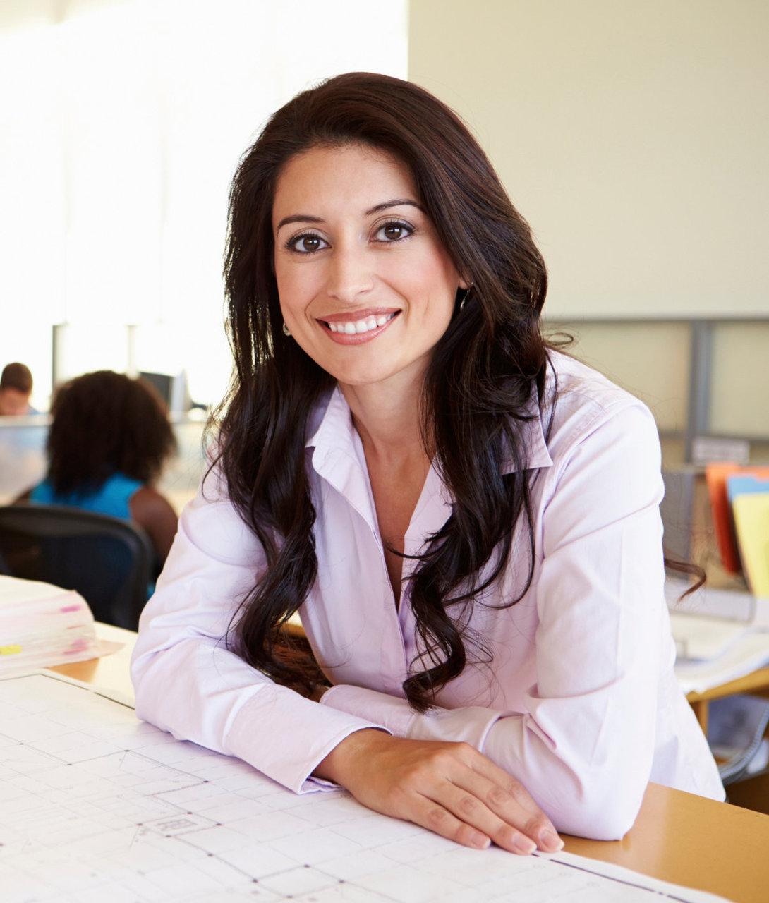 Female Architect Studying Plans In Office